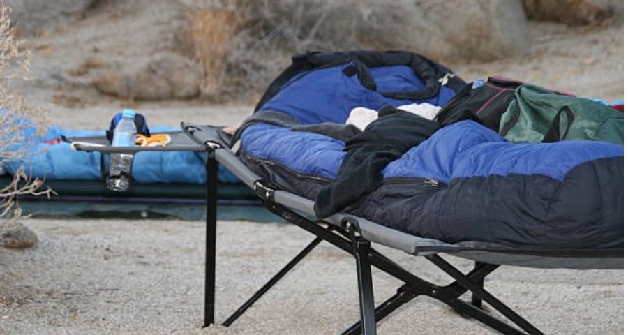 Cama de Camping vs Colchón de Aire - persona durmiendo en cama de camping